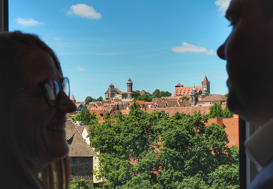 Blick auf die Kaiserburg in Nürnberg mit dunklen Silhouetten von Gesichtern im Vordergrund